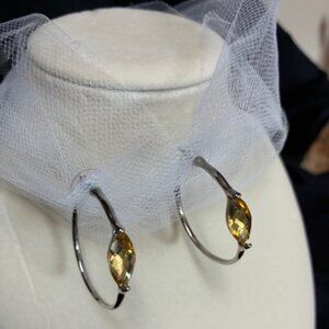 Silver tone hoop earrings with yellow rhinestones.